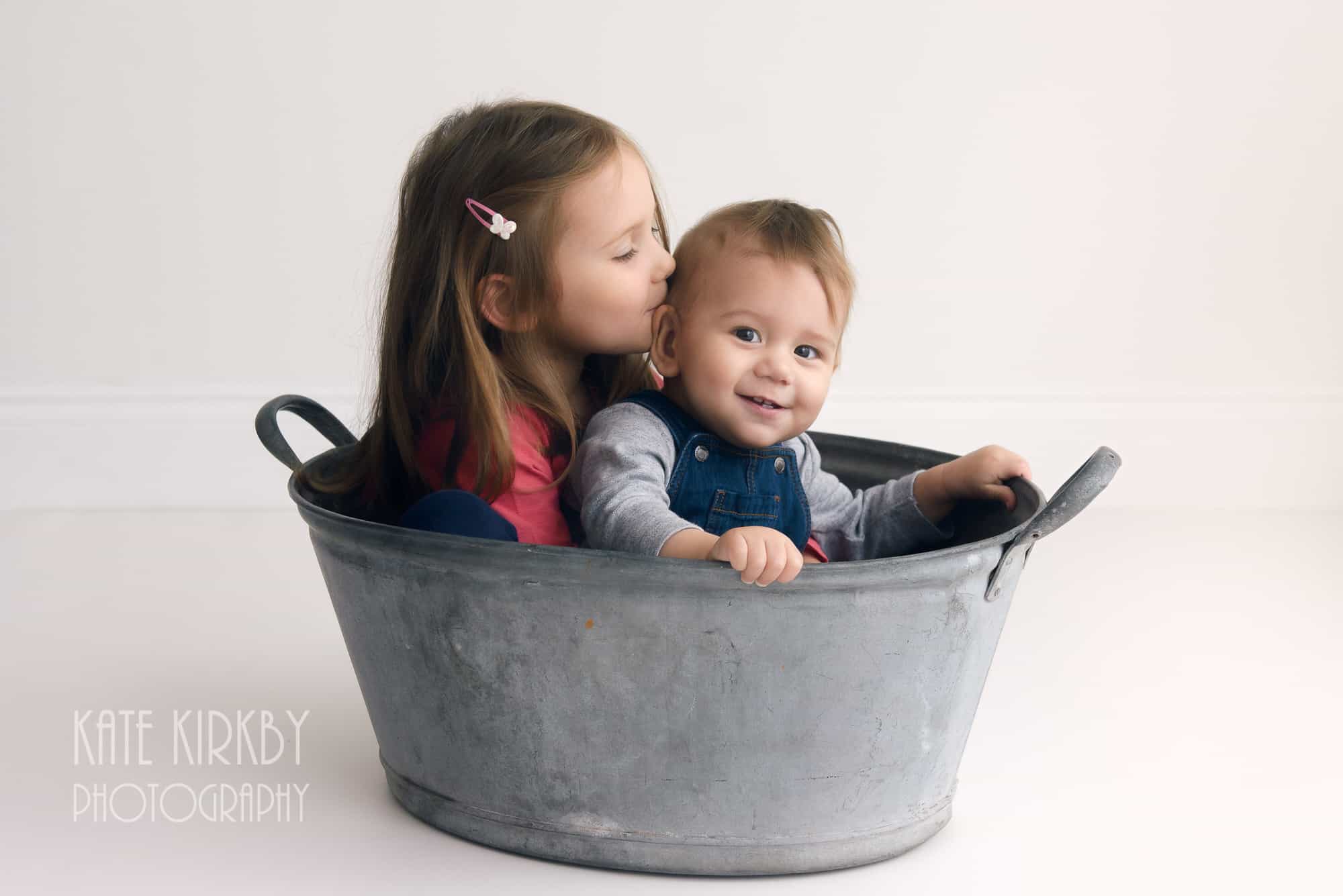 bother and sister sitting in tin bath