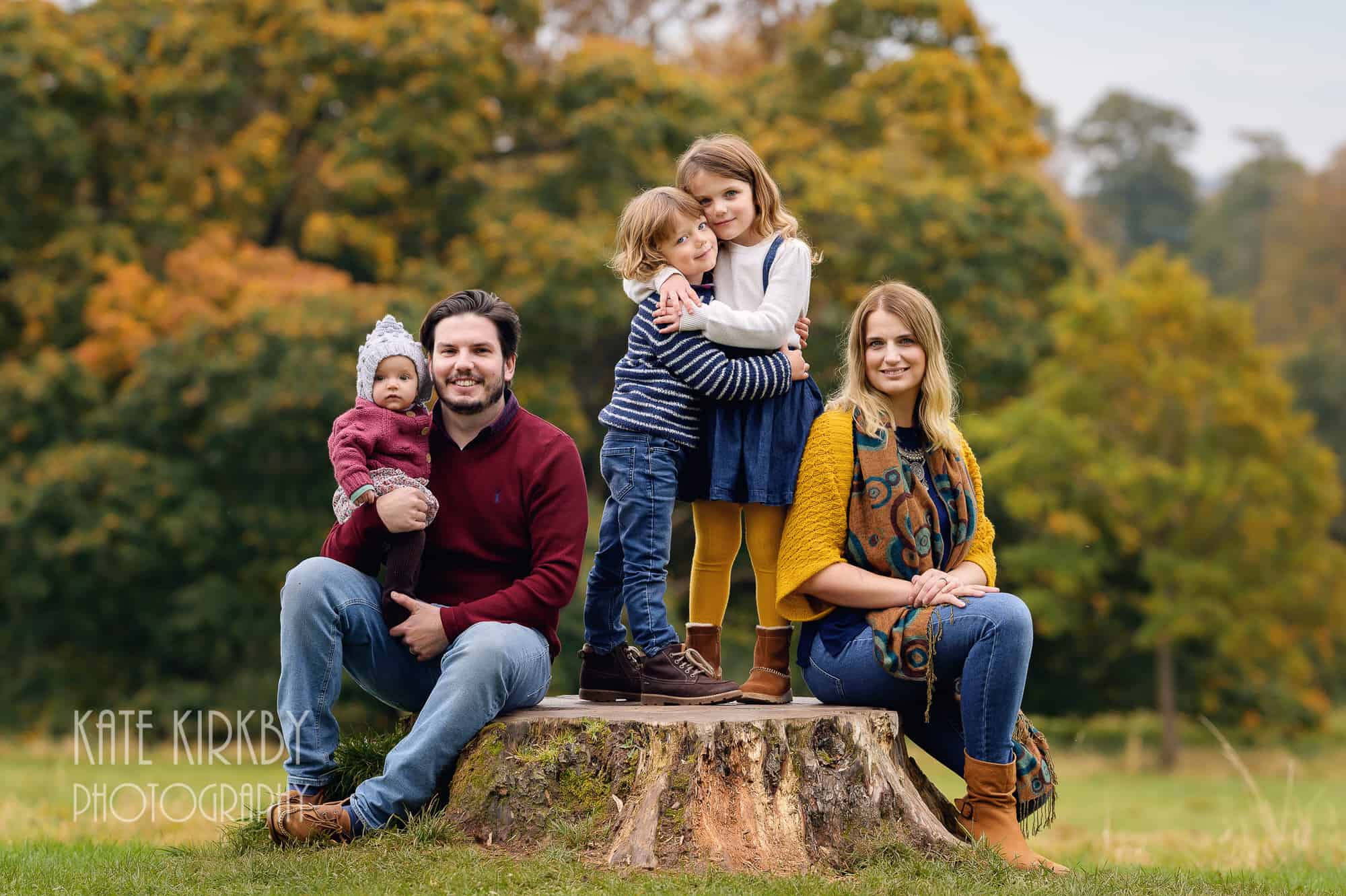 family sitting on big tree stump