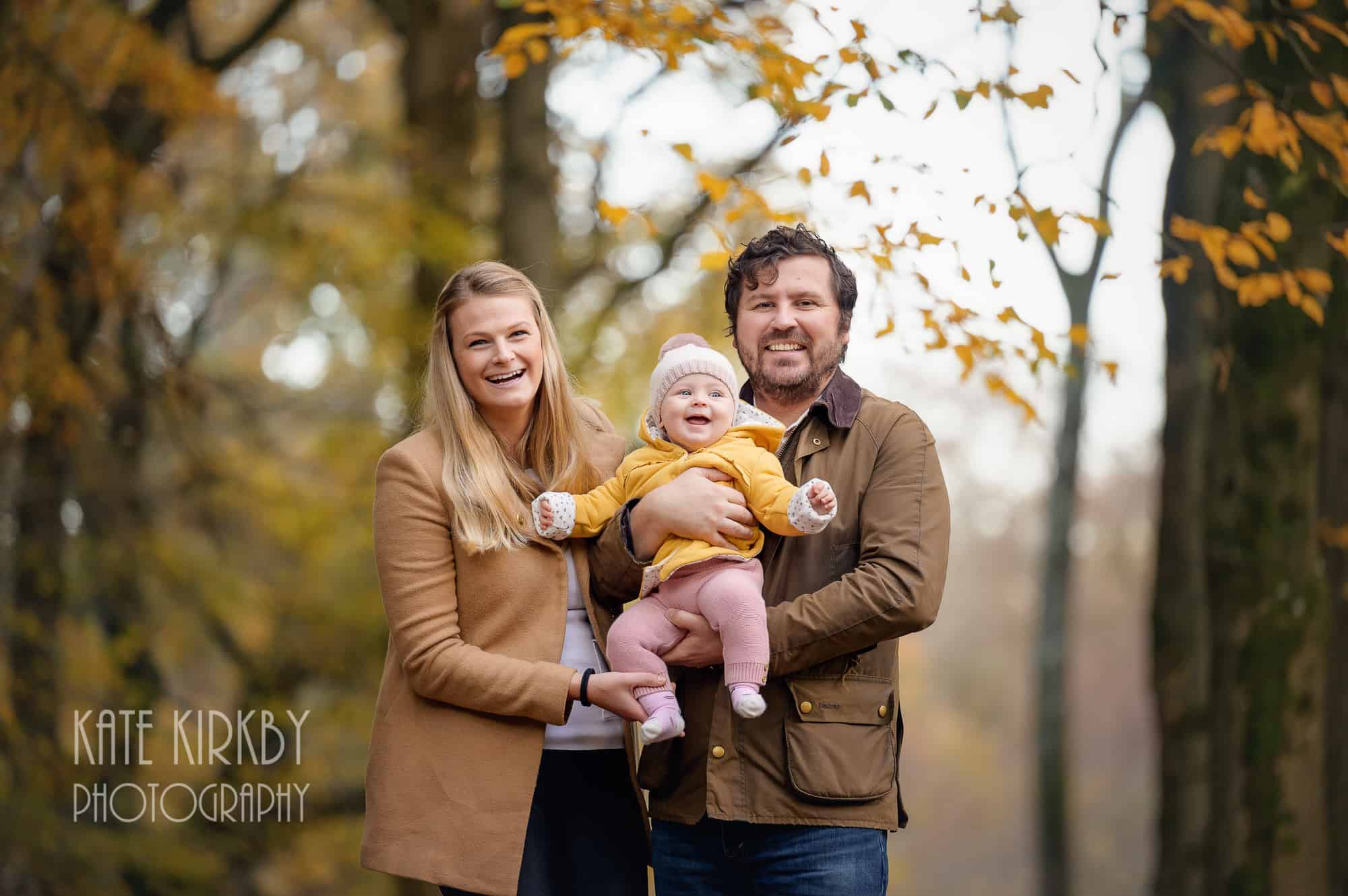 mum dad and baby in autumn woodland