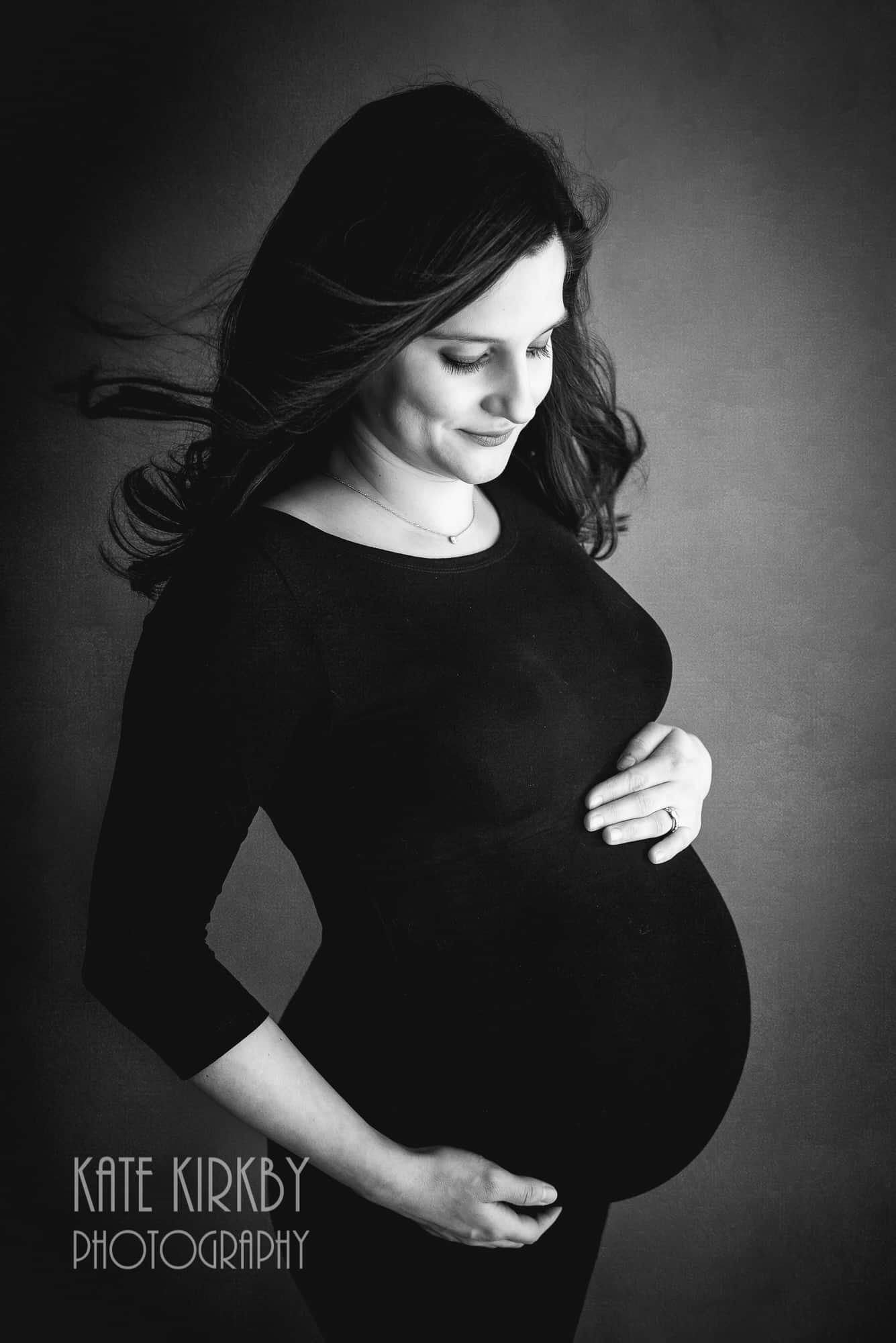 blacka nd white photo of pregnant woman in black dress