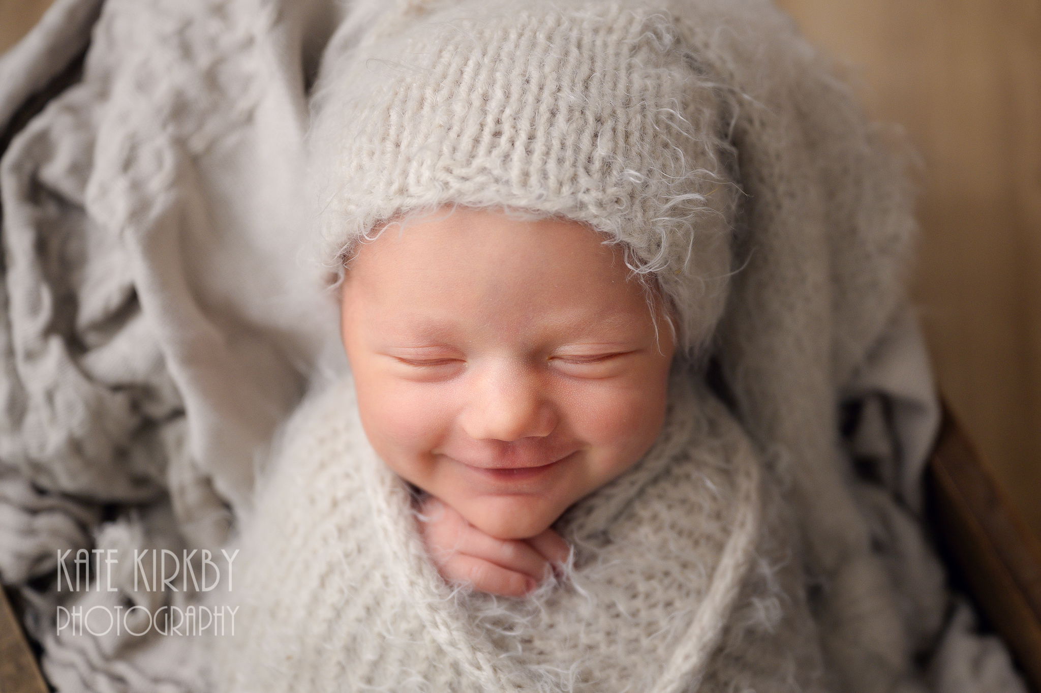 Smiling newborn in sleepy hat