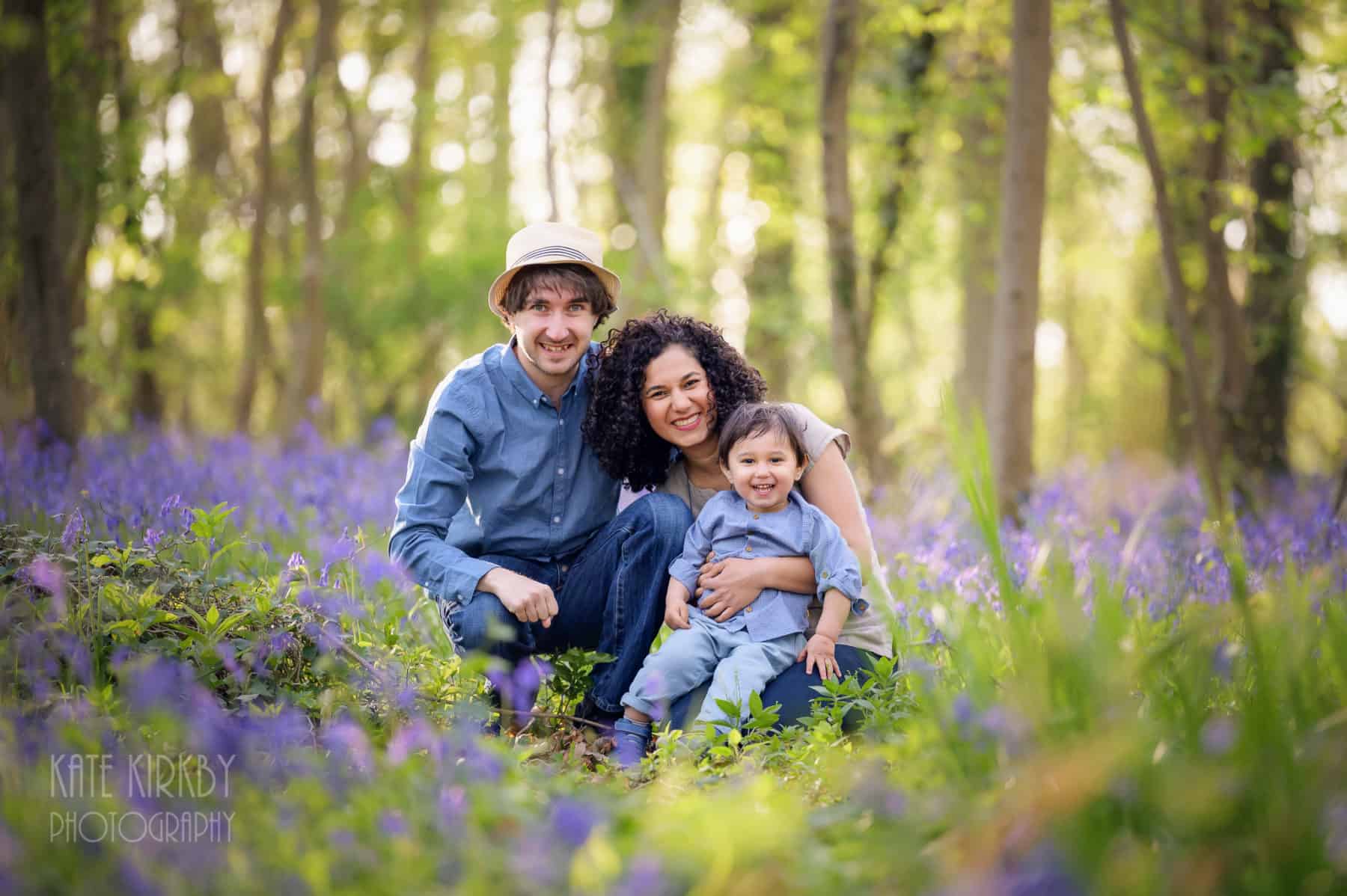 smiling family in bluebell woods