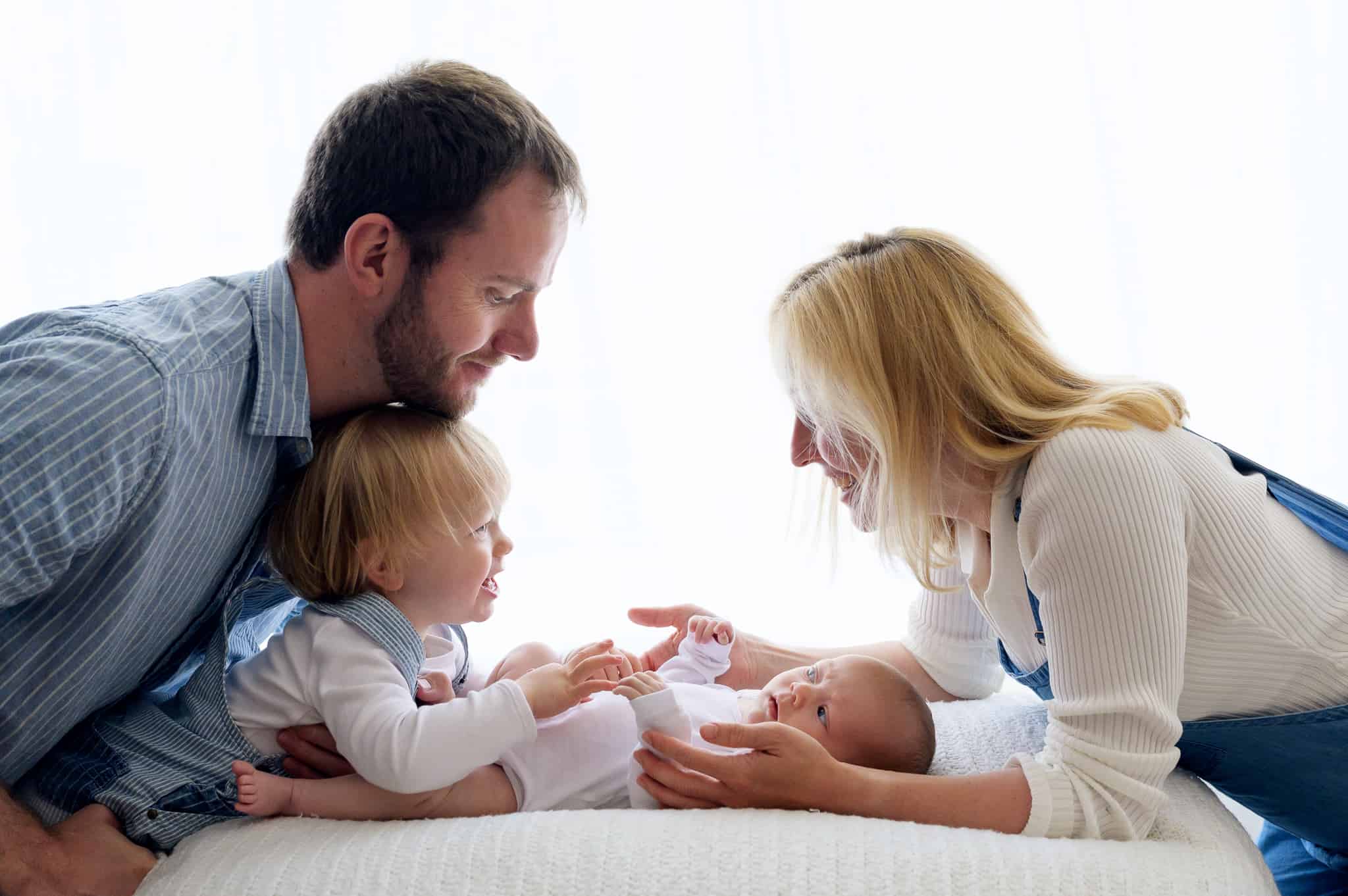 backlit family photograph with newborn and brother